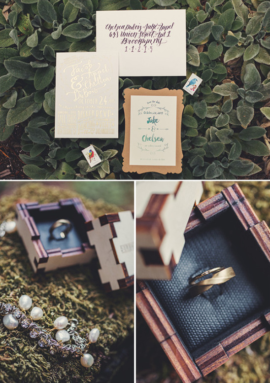 Wedding invitation suite with rings in a wooden box on foliage