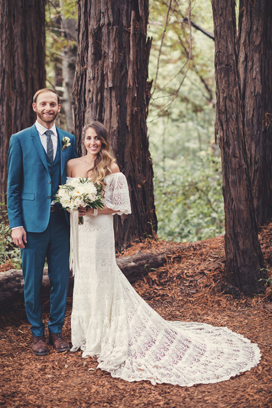 Wedding couple smiles in a redwood forest with bride's elegant dress