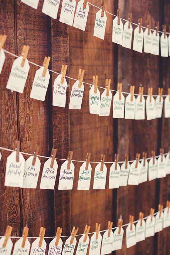 Wedding seating chart with name tags on a wooden wall