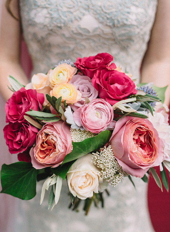 Vibrant wedding bouquet with roses and lush greenery in hand