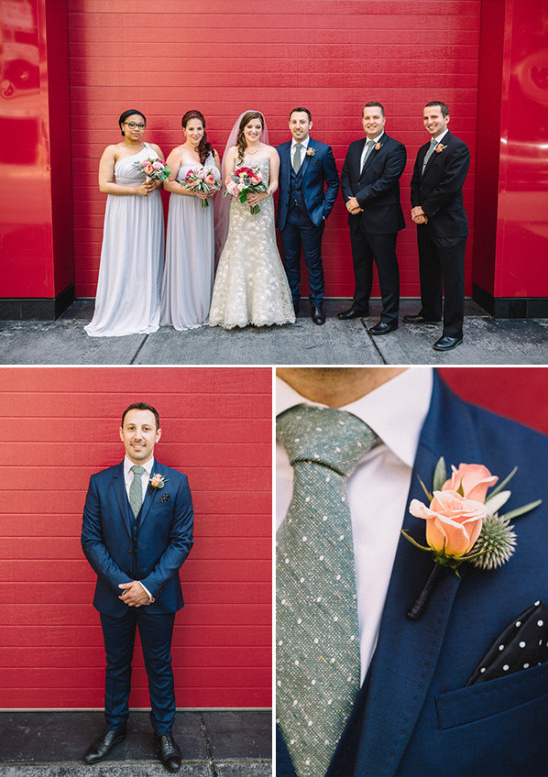 Wedding party posing in front of a red wall for a photo