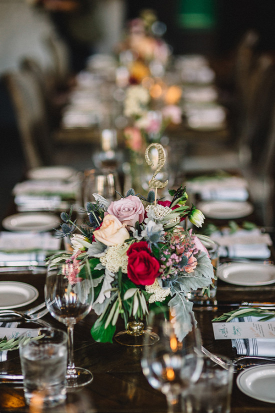 Wedding table setting with flower arrangement and gold number two