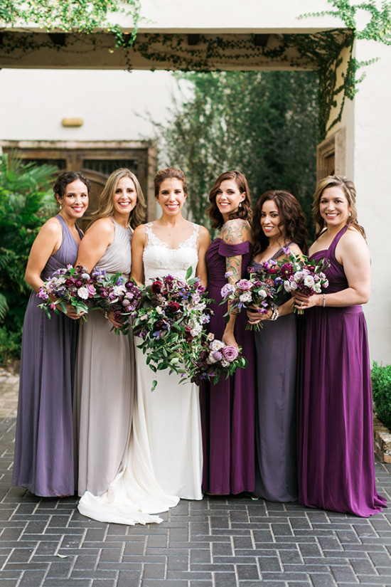 Bride and bridesmaids in elegant purple dresses holding flowers
