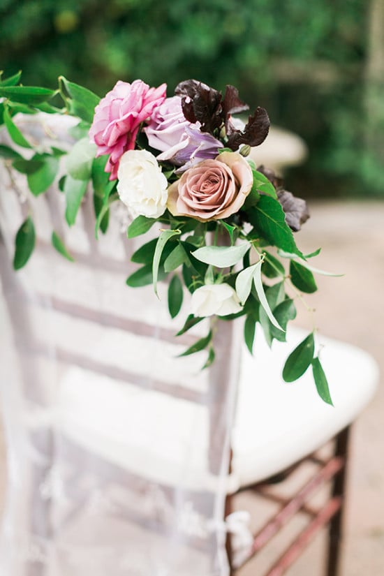 flower drapped wedding chairs