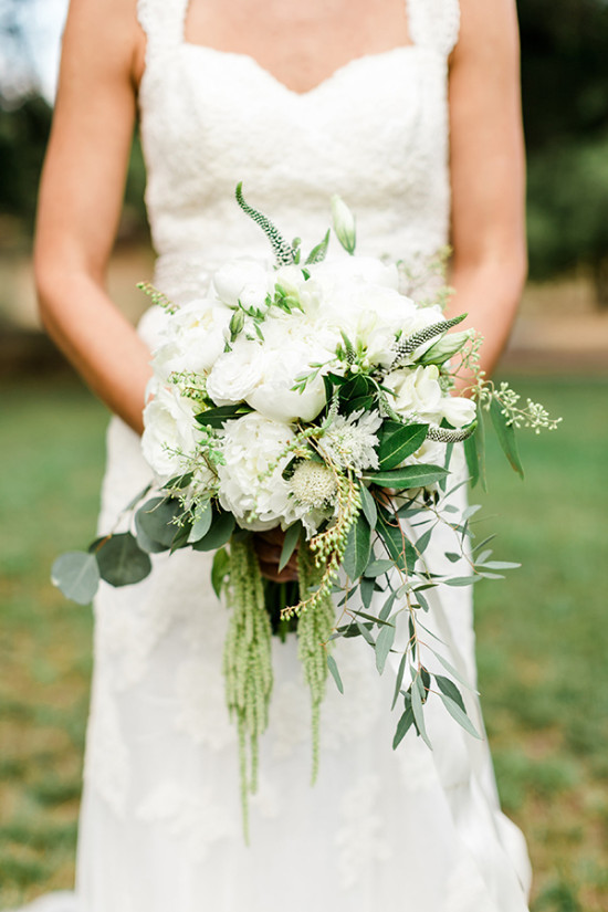 Bride in white dress holding a delicate white wedding bouquet