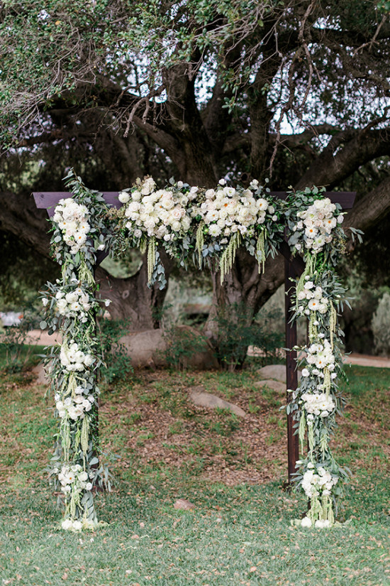 Floral archway with white flowers for a wedding ceremony outdoors
