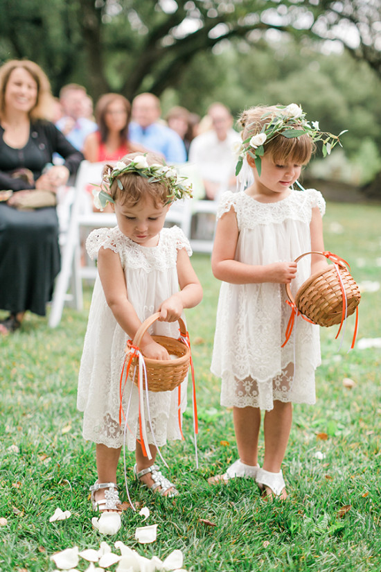 Two adorable flower girls walking at a wedding ceremony, dresses