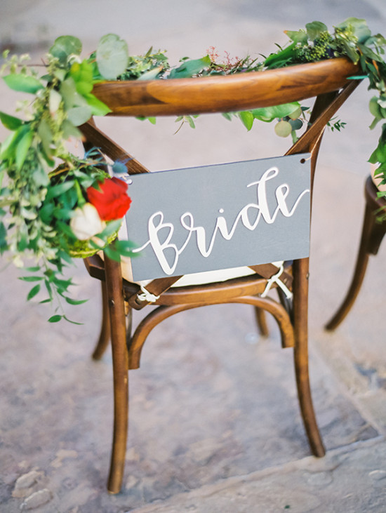Wooden chair with bride sign and wedding greenery decorations