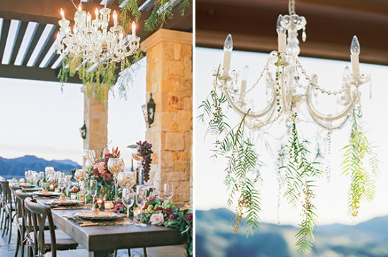 Elegant outdoor dining table with chandeliers and floral decor
