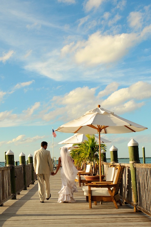 Bride and groom walk on a dock after their wedding