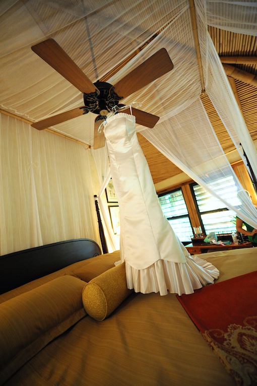 Wedding dress hanging from ceiling fan in tropical room