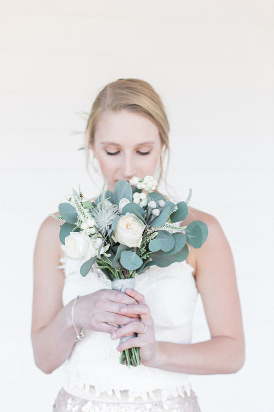 Bride smells her elegant white and green wedding bouquet