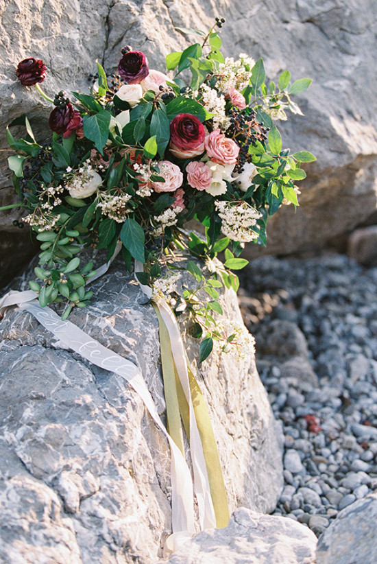Romantic roses and ribbons wedding bouquet on rocks