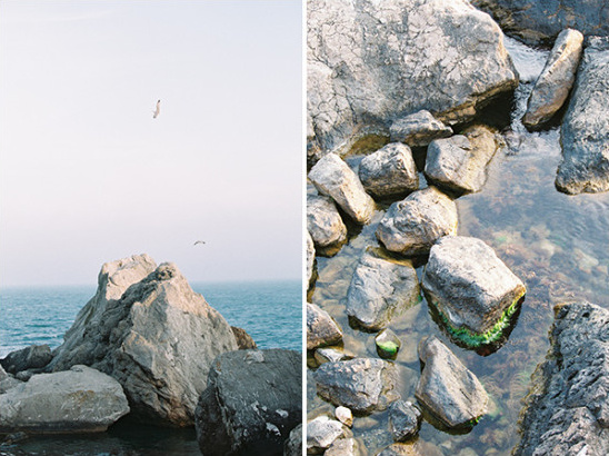 Seagulls fly over rocky cliffs at the coast shoreline