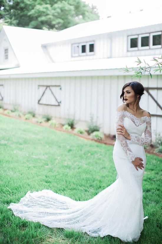Elegant bride in lace wedding dress outdoors on lawn