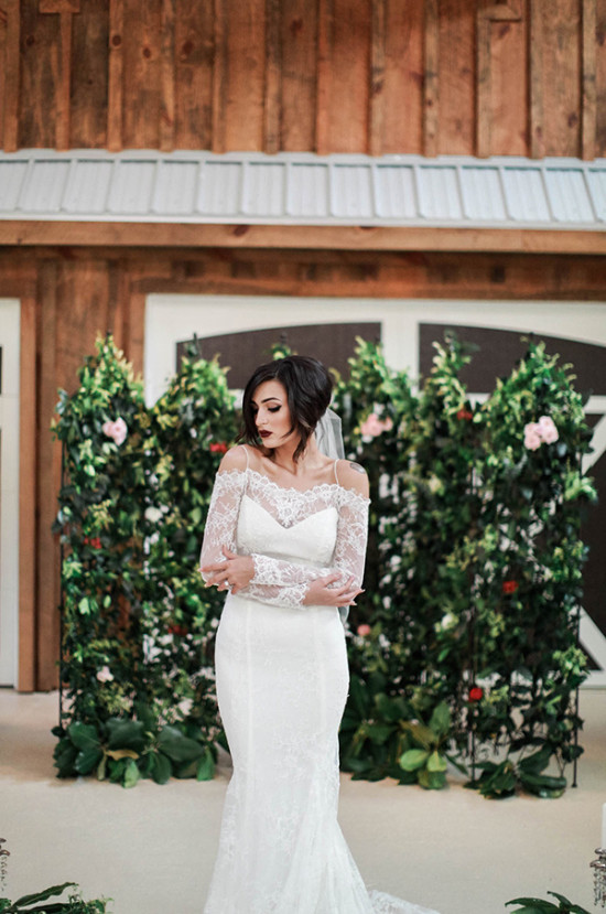Bride in lace dress at rustic outdoor wedding venue