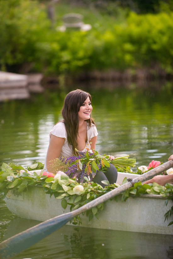 Woman in a floral-decorated boat on a serene lake