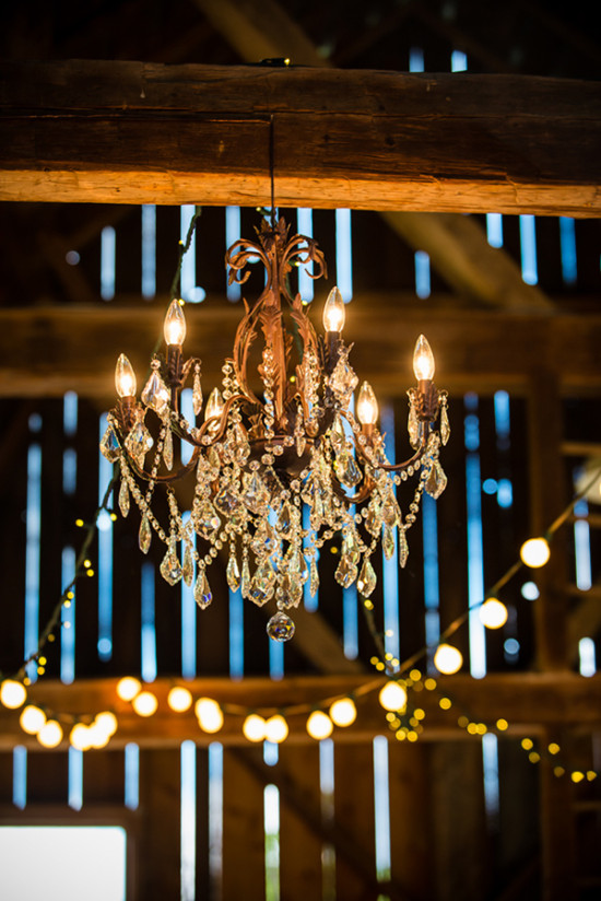 Elegant crystal chandelier in rustic wood barn setting