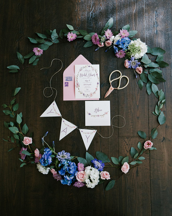 Bridal shower invitation and floral garland flat lay