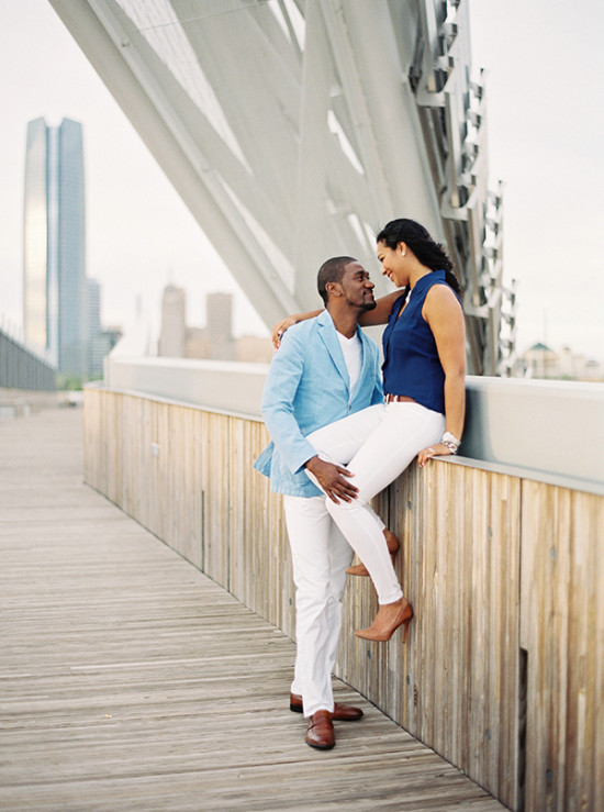 Loving couple embraces on bridge overlooking city skyline