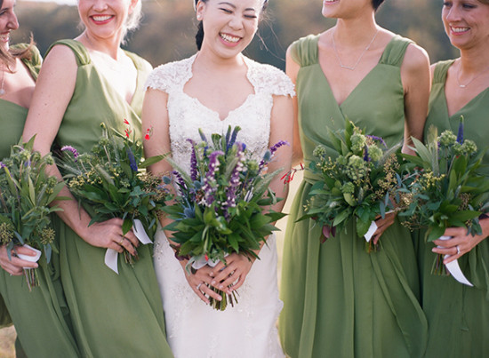 Smiling bride and bridesmaids holding wildflower bouquets