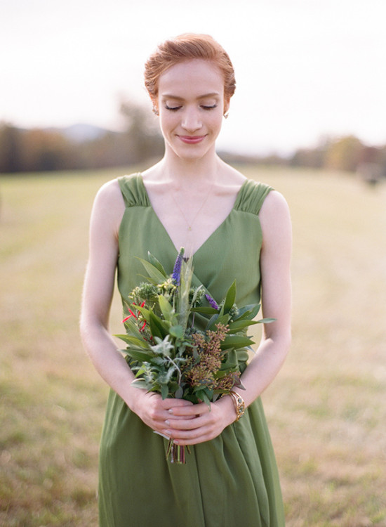 Redhead bridesmaid in green dress holds rustic bouquet