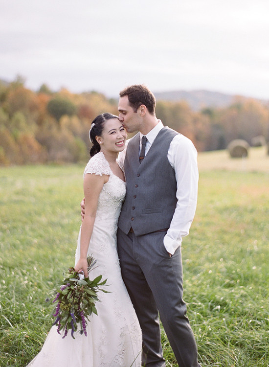 Happy bride and groom kiss at outdoor autumn wedding