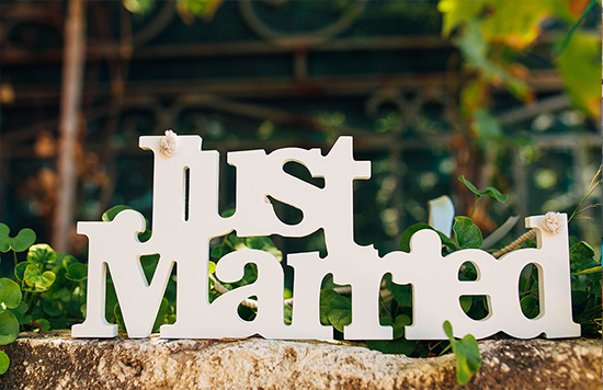 White Just Married wedding sign on stone wall outdoors