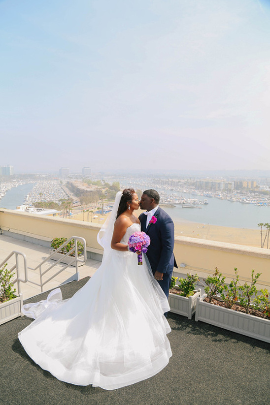 Bride and groom kiss at a waterfront wedding venue