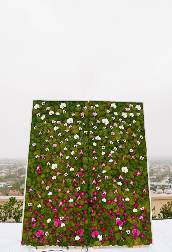 Moss and floral wedding photo booth backdrop outdoors