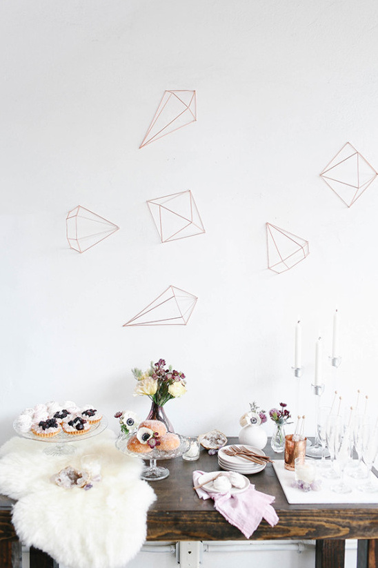 Dessert table with geometric wall decor and flowers