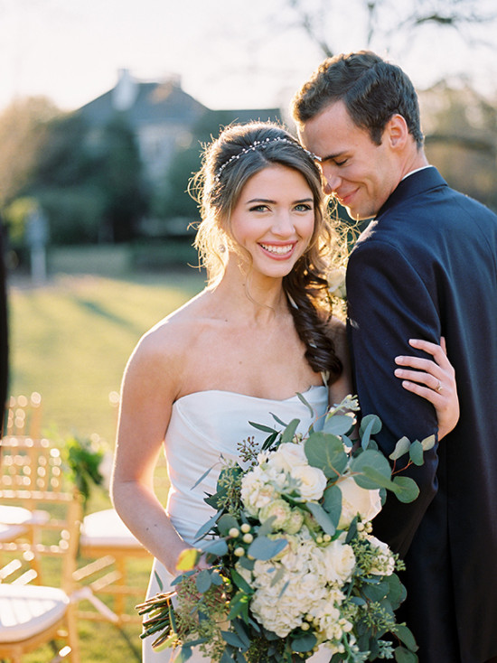 Bride and groom smiling on wedding day with bouquet