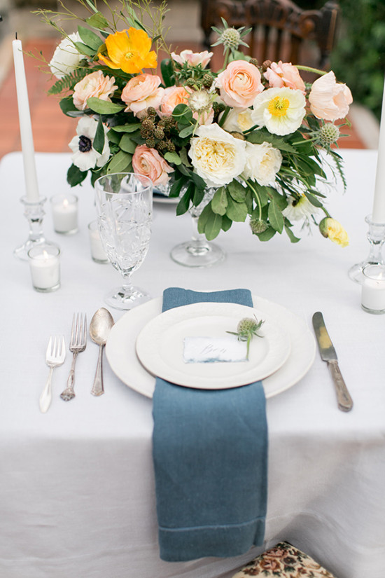 Elegant tablescape with floral centerpiece and blue napkins