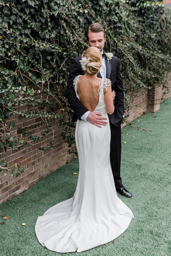 Groom embracing bride in elegant white dress outdoor