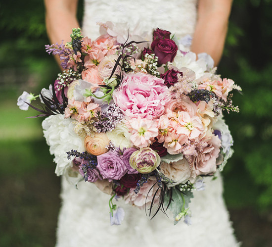 Bride holding a lush bouquet of pink and purple flowers