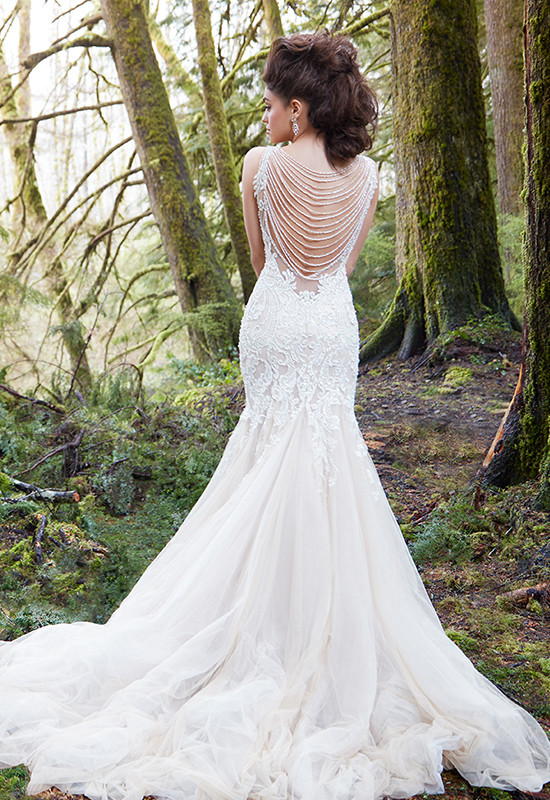 Bride in lace gown with pearl back detail in forest