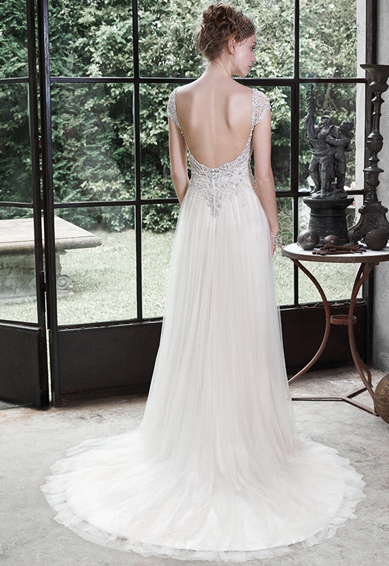 Bride in backless ivory wedding gown with beaded detail