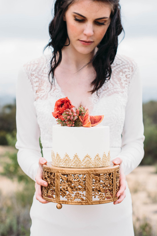 Bride holding white wedding cake golden lace flower