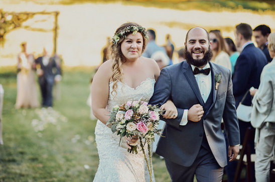 Bride and groom walking arm in arm at outdoor wedding