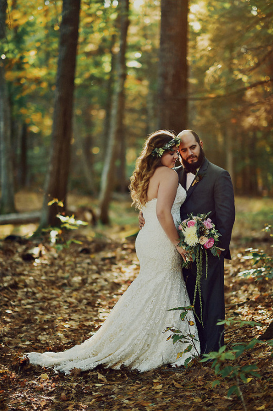 Bride and groom embrace in autumn woodland wedding