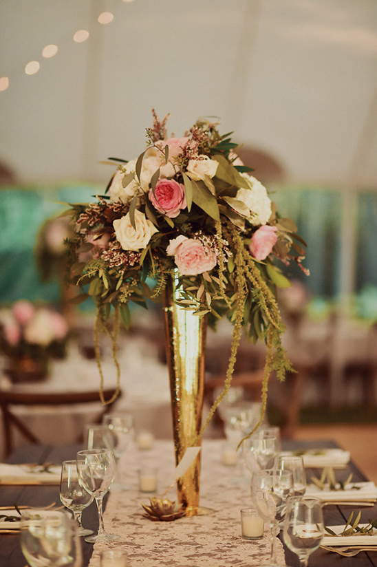 Elegant floral centerpiece with gold vase on wedding table
