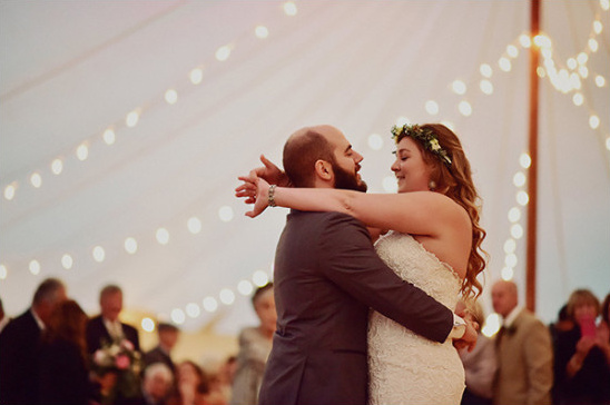 Bride and groom share their first dance under twinkling lights