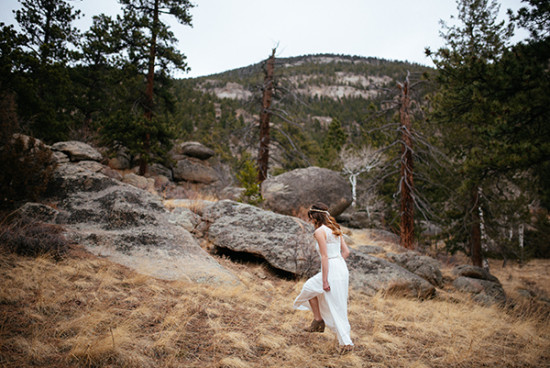 Woman in white dress hiking in a rocky mountain forest