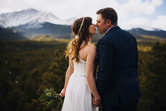 Wedding couple sharing a kiss with mountain landscape in the background