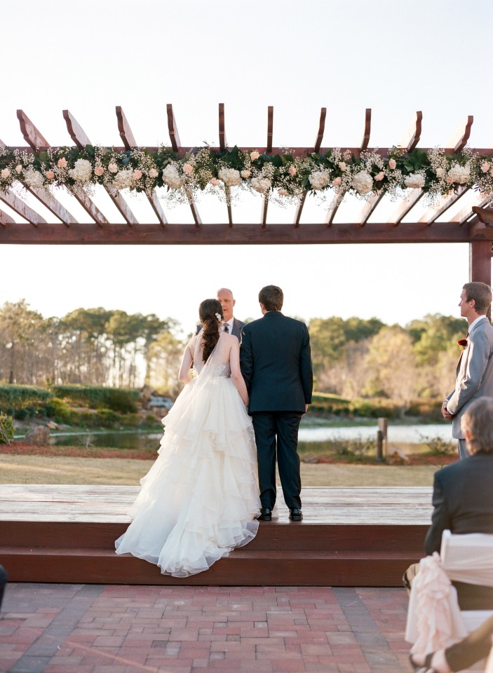 Bride and groom exchanging vows at outdoor wedding venue