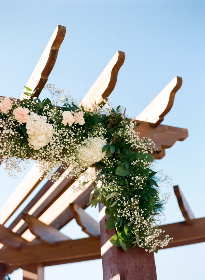 Floral decoration on a rustic wooden wedding arbor