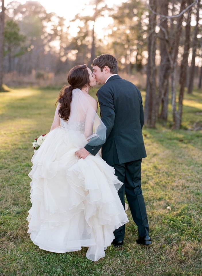 Newlyweds share a kiss on their wedding day outdoors
