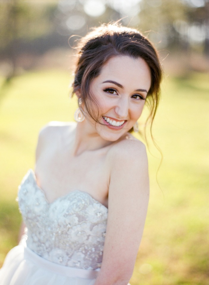 Smiling bride in white strapless wedding dress outdoors