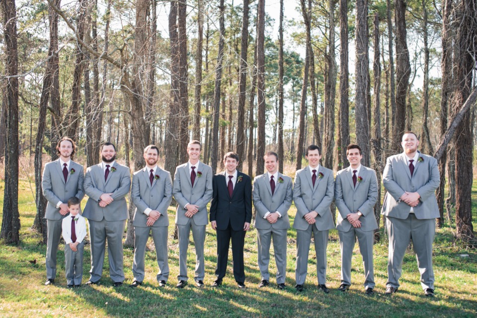 Groomsmen in grey suits with burgundy ties outdoors
