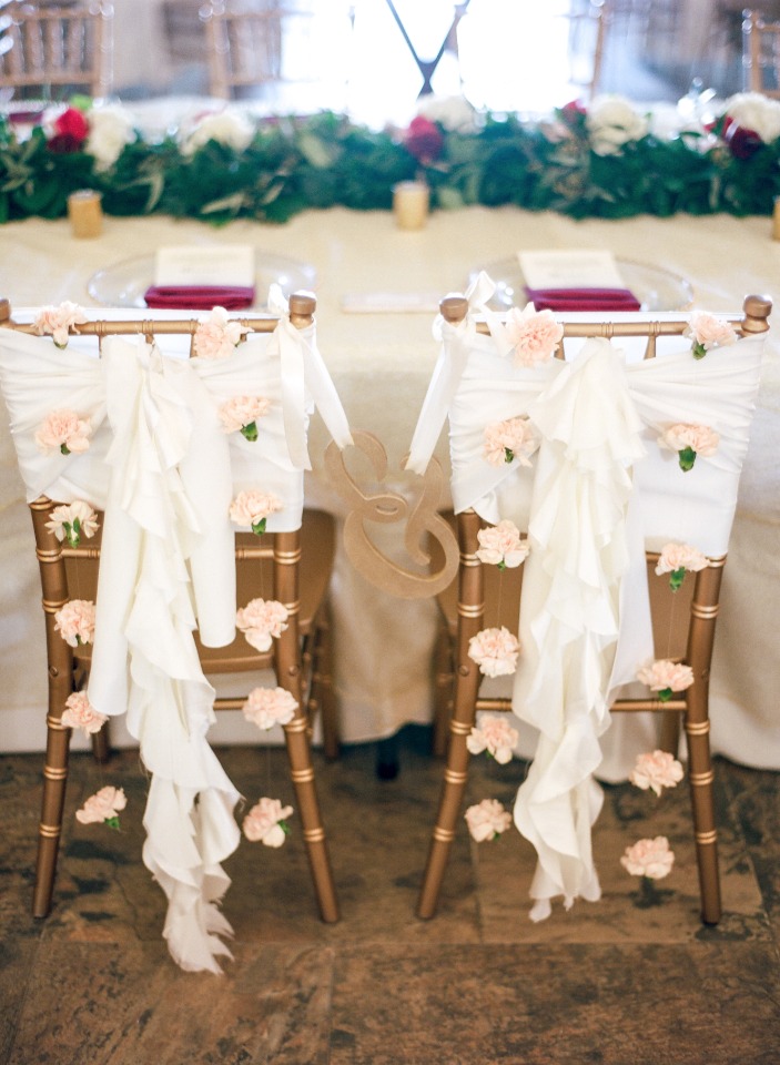 Decorated wedding chairs with flowers and white fabric